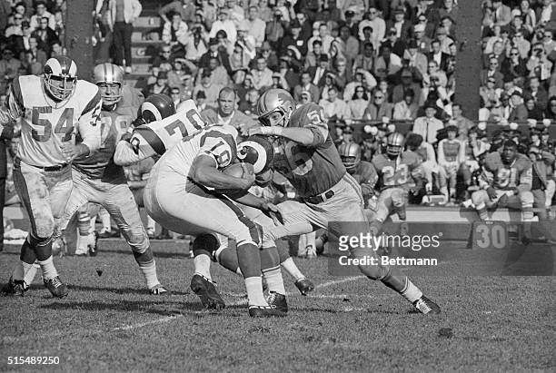 Lions linebacker Joe Schmidt, grabs hold of the helmet of Rams quarterback Roman Gabriel to bring him down for a six-yard loss on the Rams 31-yard...