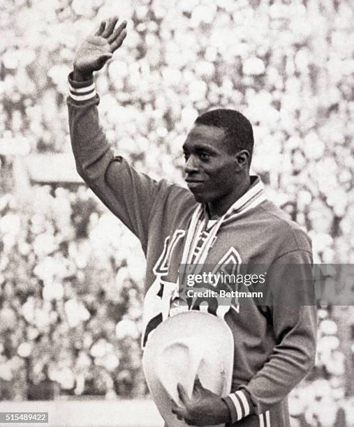 Tokyo, Japan- America's Bob Hayes, winner of the gold medal in the Olympic 100-meter dash, is flanked by silver medalist E. Figerola of Cuba and...