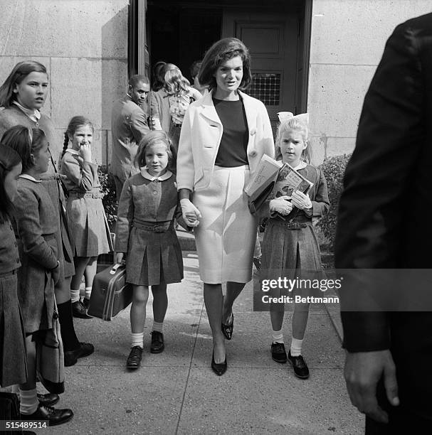 Little girl giggles as Mrs. Jacqueline Kennedy picks up her daughter, Caroline and her niece, Sydney Lawford at the end of the school day. The young...