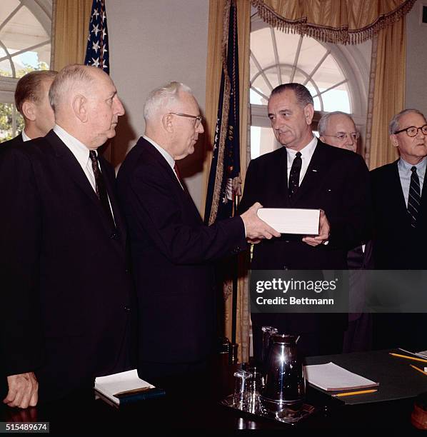 The Warren Commission hands to President Johnson at the White House today its voluminous report on the Kennedy assassination. Left to right: John J....