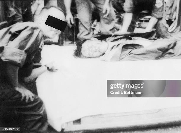 Body of Ngo Dinh Diem. Lying in the armored personnel carrier. A smiling Vietnamese officer leans over him. Diem and his brother chief advisor were...