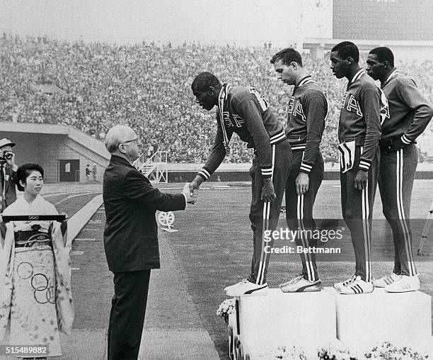 International Olympic Committee Chairman Avery Brundage congratulates Otis Paul Drayton of the United States after presenting the gold medal to...