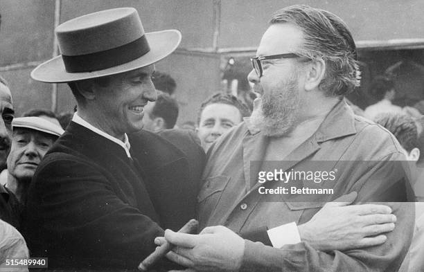 Toting a large cigar, Orson Welles, who has known recent fame as a "toros" fan, greets one of Spain's most famous bullfighters , Luis Miguel...