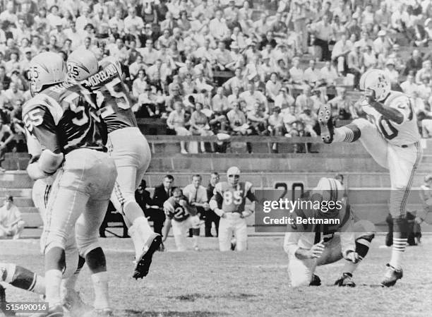 Boston Patriots' kicker Gino Cappelletti boots a field goal, with quarterback Babe Parilli holding, during a game against the Chargers in San Diego....