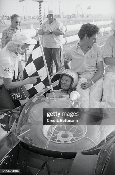 Riverside, California: New Zealander Bruce McLaren gets the checkered flag after he finished nearly half a lap ahead of his nearest competitor here...
