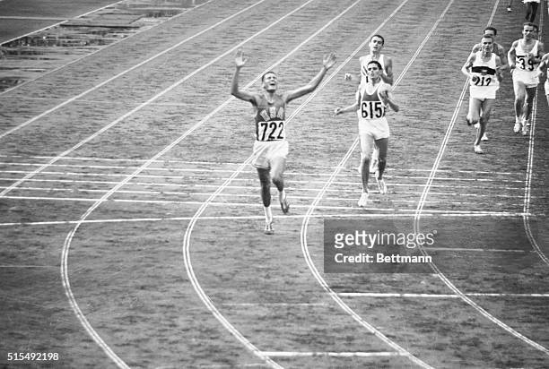 Billy Mills displays joy after crossing finish line winning 10,000 meter race in Olympic record time of 28:24.4. 2nd was Mohammed Gammoudi of Tunisia...