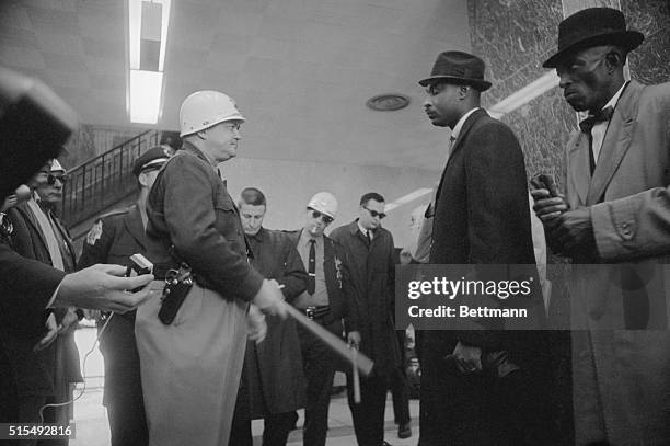 Dallas County Sheriff Jim Clark waves a nightstick as he tells a group of African-Americans taking part in the Selma Voting Rights Campaign, to leave...