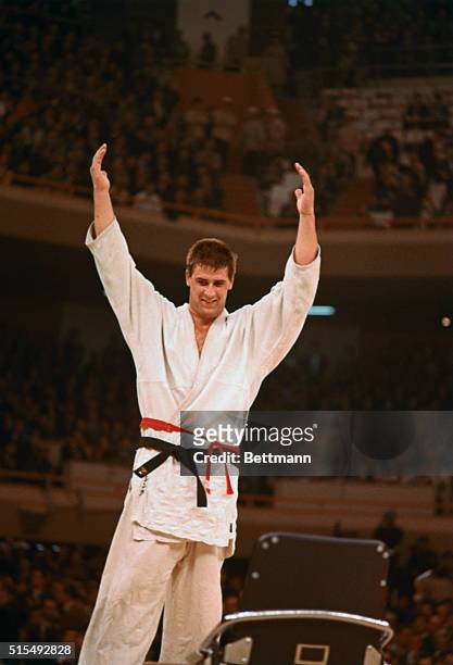 Tokyo, Japan: Anton Geesink of the Netherlands raises his arms after defeating Kaminaca of Japan to win gold medal in the open class Judo event.