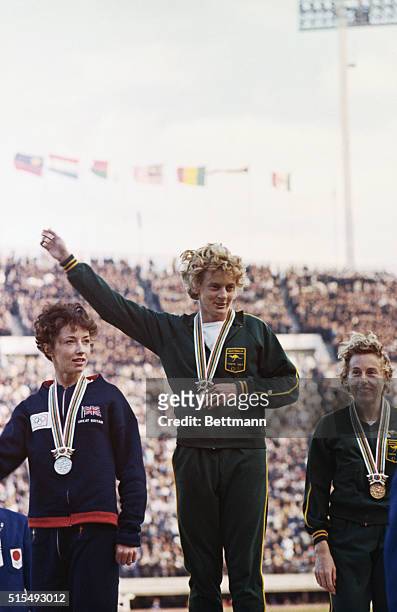 Tokyo, Japan: Betty Cuthbert, Olympic athlete in center after taking first place in the women's 400 meter run. In seciond place at left is Ann Packer...