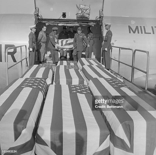 Caskets containing the bodies of nine U.S. Servicemen killed in Vietnam are unloaded from USAF transport plane in which they arrived here 2/11 from...