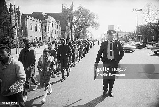 Selma, Alabama: Singing "freedom songs" and under police guard, hundreds of school children march down the middle of the street toward a detention...