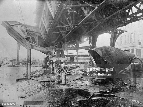 Elevated train structure is a twisted mass of metal on Atlantic Ave. After the "Great Molasses Flood of 1919". A huge tank containing more than...