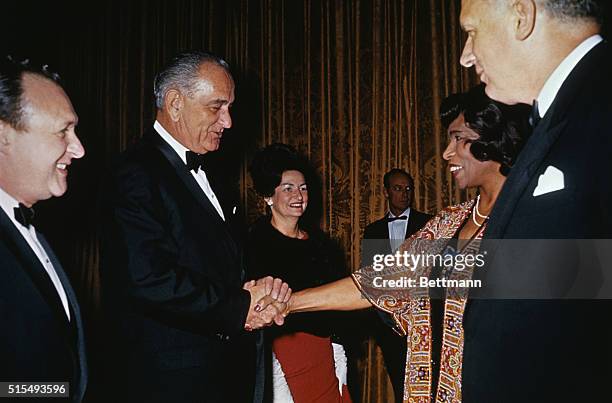 Washington, DC: Opera singer Marian Anderson with President Johnson, shaking hands as they are introduced at a State Department Reception prior to...