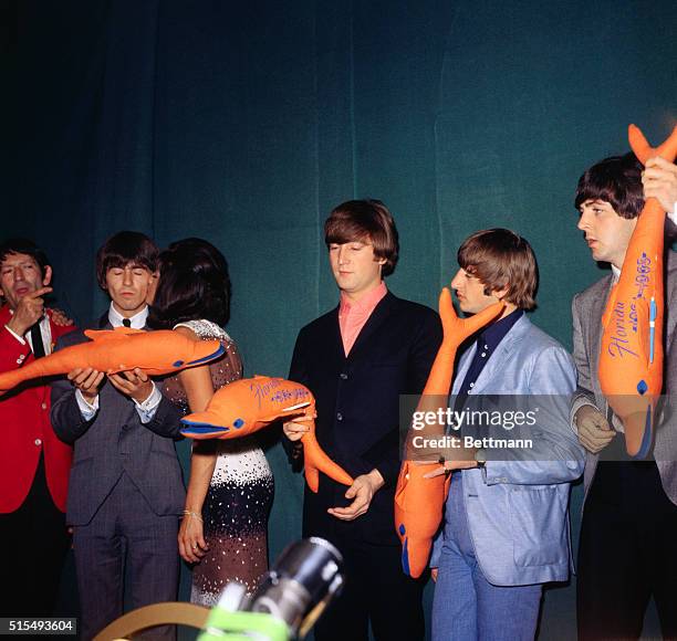 Pat Pearce, Rep. Of Florida Pavilion of the World's Fair, comes to Beatles, as they could not come to fair. She presents them with orange porpoises,...