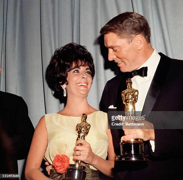 Los Angeles, CA: Burt Lancaster and Liz Taylor, winners of Best Actor and Actress Awards, holding their Oscars.