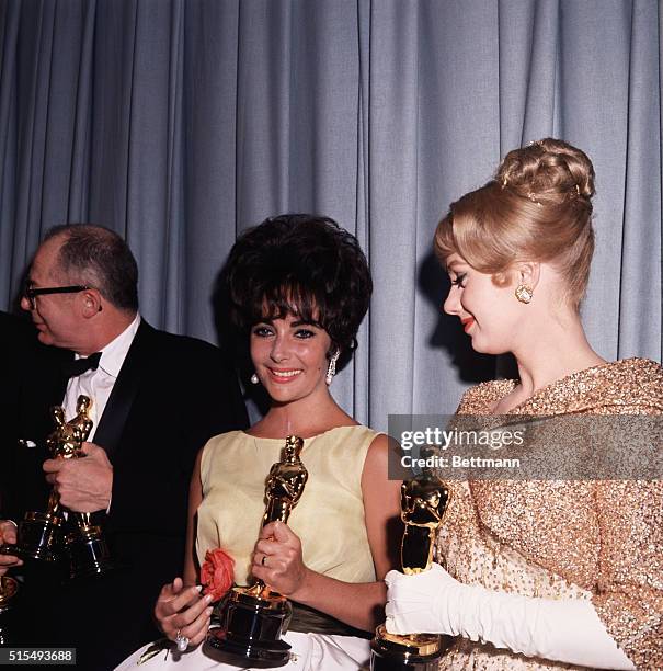 Los Angeles, CA: Burt Lancaster, Liz Taylor, winners of Best Actor and Actress Awards, holding their Oscars. Also with them is Shirley Jones, winner...