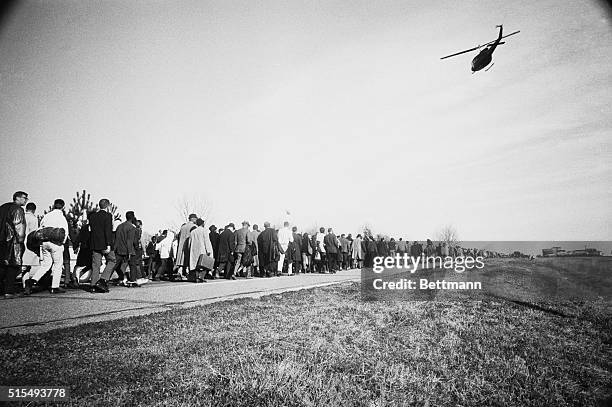 Selma, Ala.: Long line of puddling civil rights marchers is watched over by National Guard helicopter which kept the column under continual...