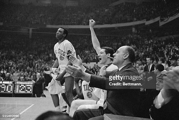 Boston Celtics coach Red Auerbach with basketball players John Havlicek and Willie Naulls show their joy as the game against the Los Angeles Lakers...