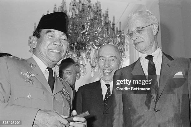 Special Envoy Ellsworth Bunker, right, and Ambassador Howard P. Jones, center, chatting with Indonesian President Sukarno April 6 at the Presidential...