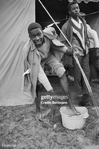 Montgomery, Alabama: Johnnie Manuel of Selma, washes the mud off his feet as he and other freedom marchers halted, March 23, after their third day's...