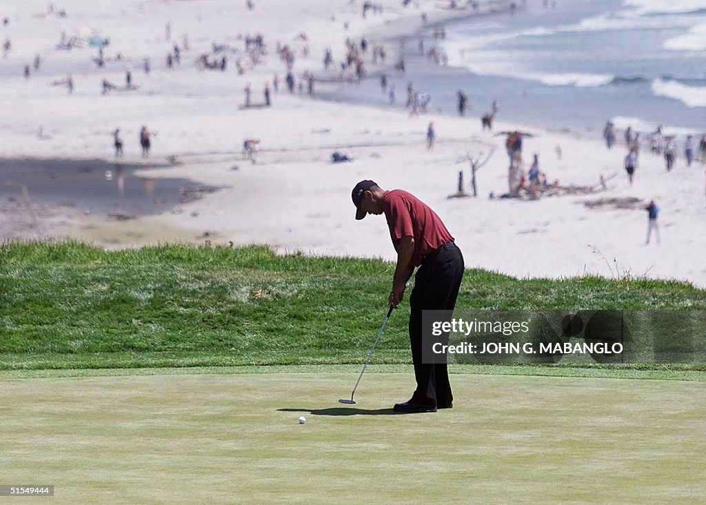 Tiger Woods putts on the ninth green during the fi