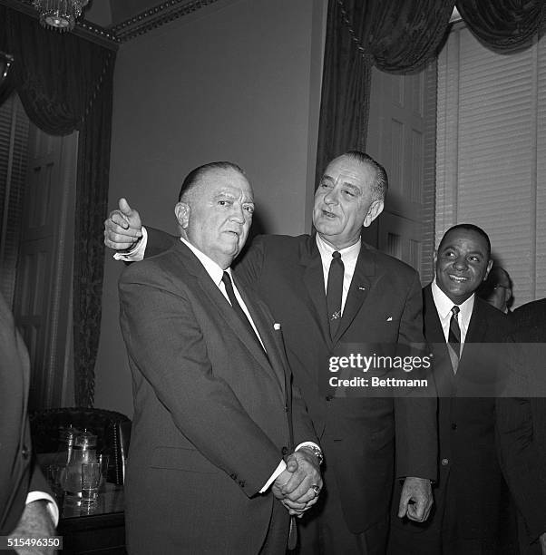 President Johnson reaches up to put his arm around J. Edgar Hoover, Director of the FBI, as they met in the Speaker's Office after the chief...