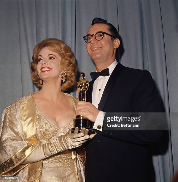 Steve Allen, comedian, at the Academy Awards of 1961- with wife Jayne Meadows, holding Oscar which they will present for the best song used in an...