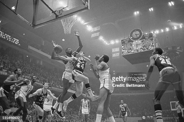 Lakers' Jerry West is guarded closely by Celtics' Bill Russell as he goes in for a layup, 3rd period, 1st game of championship playoffs of the NBA,...
