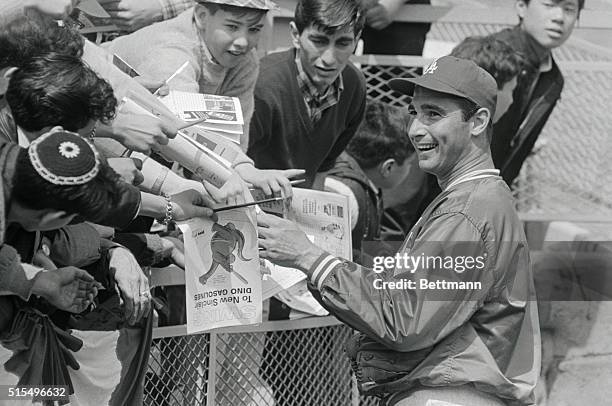 Sandy Koufax, Los Angeles Dodgers star pitcher, who made news April 12th by Not pitching opening day, obliges fans with autographs at Shea Stadium...