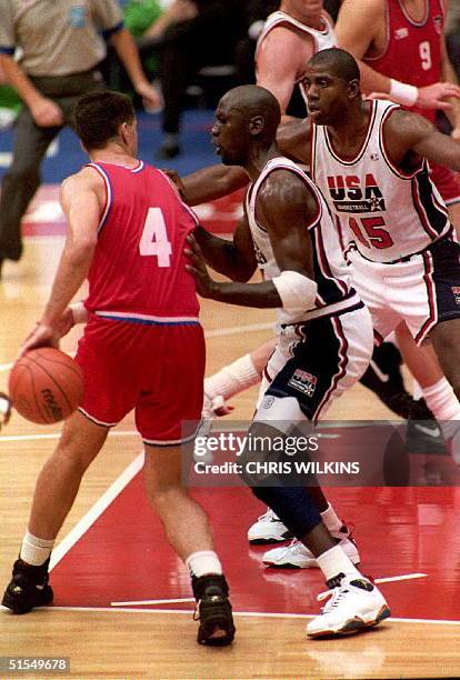 Croatian Drazen Petrovic is guarded by U.S. Michael Jordan and Magic Johnson 08 Aug during the final game of the basketball competition at the '92...