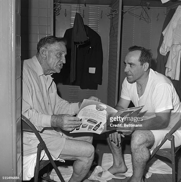 New York Mets manager Casey Stengel, left, chats with Mets' coach Yogi Berra in dressing room at Wrigley Field here 6/2 after game with the Cubs was...