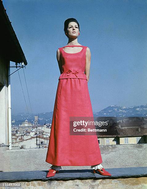 Red linen creates this evening dress from the Emilio Pucci Spring 165 collection. The long dress, which has lacy-cuffed pants peeking below the...