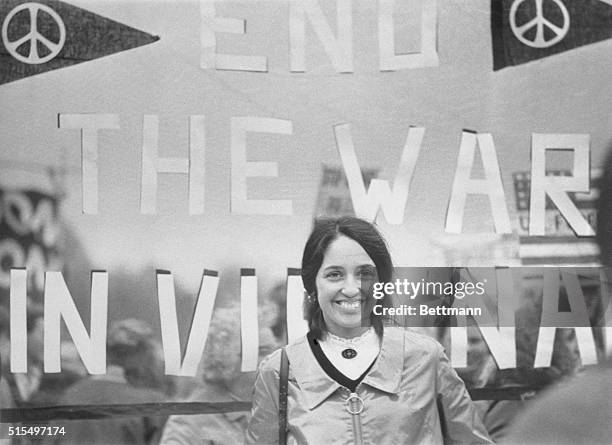 London, England: Singer Joan Baez strumming guitar during protest march in Trafalgar Square.