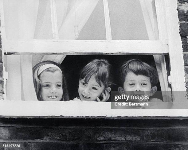 Caroline Kennedy and her cousins Tina and Anthony Radziwill play peek-a-boo with newsmen gathered before the Radziwill residence here. Mrs....