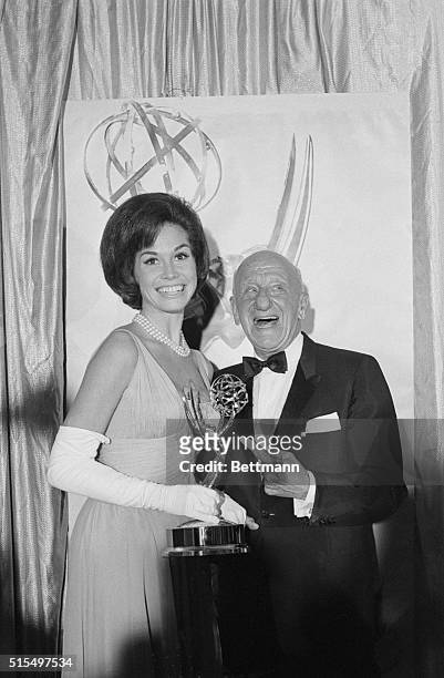 Mary Tyler Moore, costar of The Dick Van Dyke Show, accepts the show's Emmy Award from Jimmy Durante. Van Dyke and singer Barbra Streisand won the...