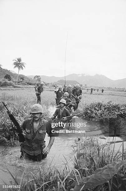 Vietnam: Picture shows a troop of US soldiers wading through the water. Undated photo circa 1960s.