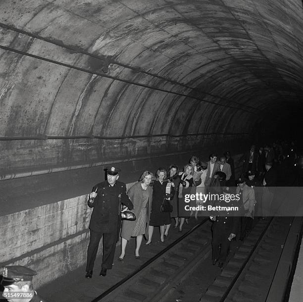 Policemen lead commuters through a subway tunnel where they were trapped late November 9th when power failure stopped all trains. The black out...