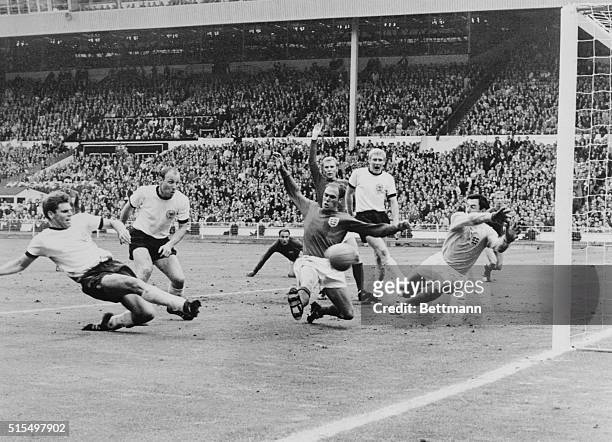 Germans score twice...Wolfgang Weber of West Germany scores his team's second goal as England's Ray Wilson and goalie Gordon Banks try to stop ball...