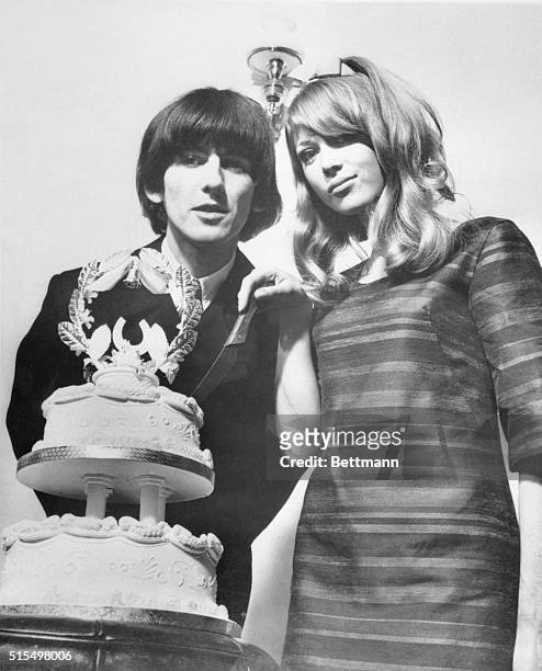 Esher, England: Beatle Wedding. Beatle George Harrison and model Patti Boyd cut the wedding cake during the reception at his home here following...