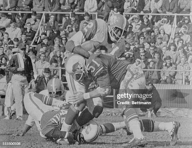 Denver Broncos' running back Cookie Gilchrist is stopped after a short gain by Buffalo Bills' defensive backs Butch Byrd and linebacker John Tracey...