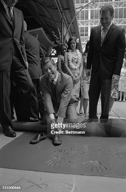 Dick Van Dyke's expression would seem to indicate that he would have preferred the cement a little softer as he tries to pry free his shoes after he...