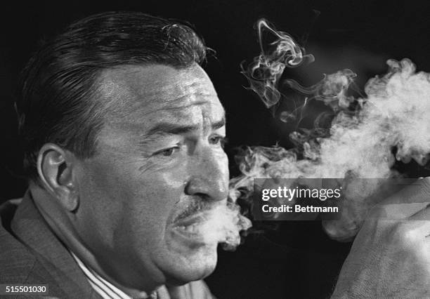 The room is smoke-filled as Democratic representative Adam Clayton Powell speaks to the press after celebrating his 38th anniversary with the...