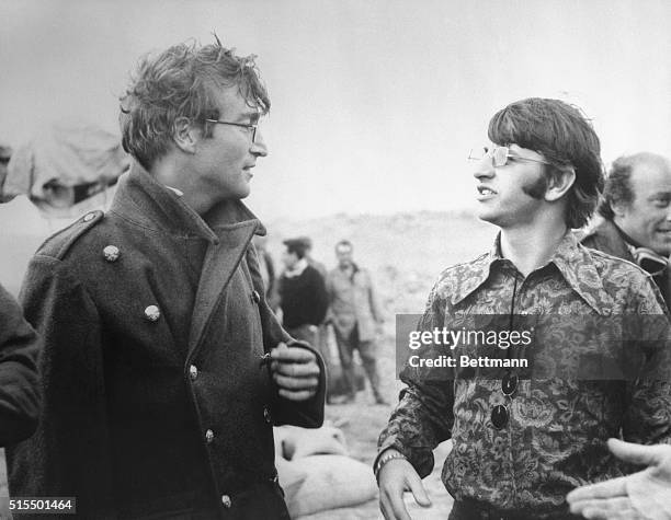 On location...The Beatles' John Lennon chats with fellow Beatle Ringo Starr during a break on the set of his new movie here. Lennon is appearing in...