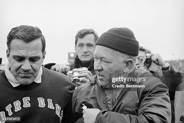 Notre Dame coach Ara Paraseghian walks off the playing field with Michigan State coach Duffy Daugherty after their teams battled to a 10-to-10 tie at...