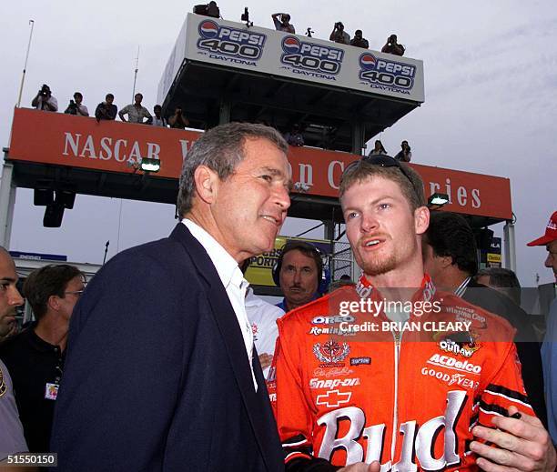 Driver Dale Earnhardt Jr. Talks with Texas Governer and US presidential candidate George W. Bush before the start of the Pepsi 400 NASCAR race in...