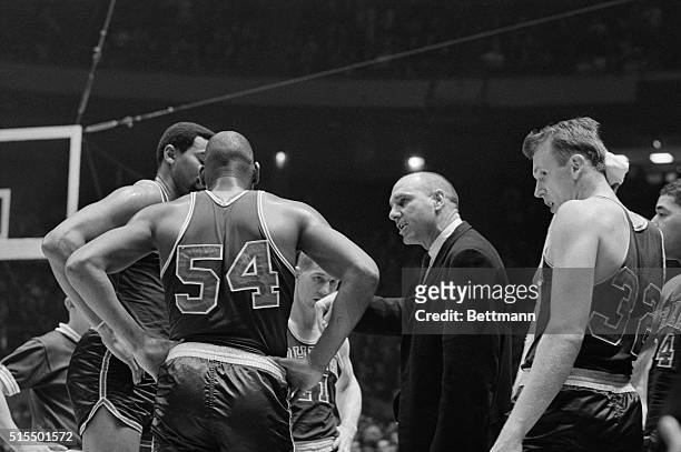 Philadelphia 76ers coach Art Hannon instructing Wilt Chamberlain and Lucius Jackson during game with New York Knicks.