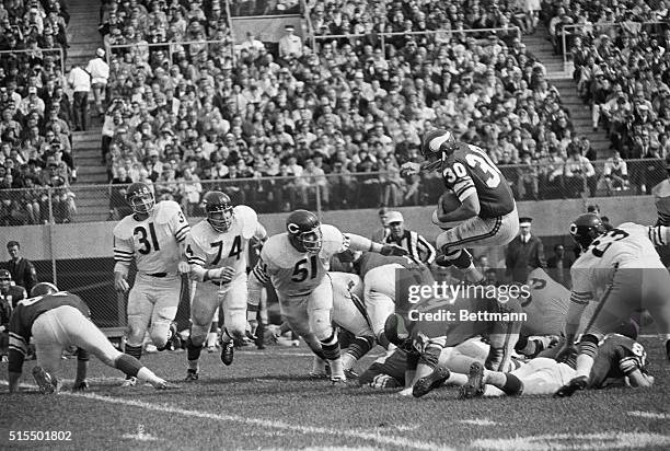 Minnesota Vikings fullback Bill Brown , the NFL's leading rusher, jumps over a pile of linemen for three yards in the second quarter of this game...