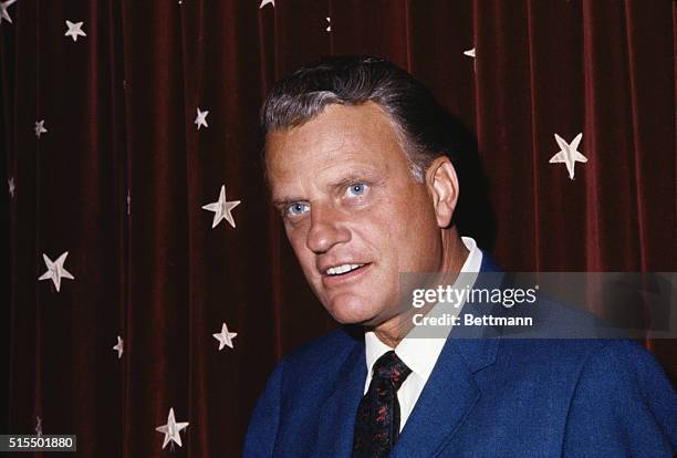 Close-up photo shows evangelist Billy Graham in front of an American flag.