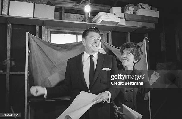 Pacific Palisades, Calif.: Ronald Reagan and his wife, Nancy emerge from voting booths after casting their ballots. Reagan, Republican gubernatorial...