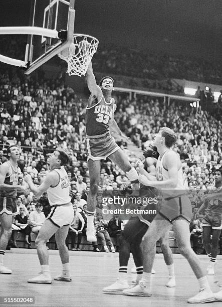Lew Alcindor - #33 of the UCLA Bruins and the future Kareem Abdul-Jabbar - makes two points while sailing over Stan Green and Rich Wright of Georgia...